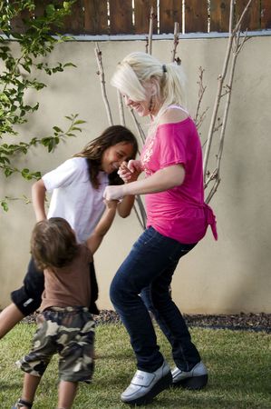mother playing with her sons in the lawn