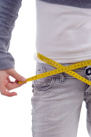 female measuring her waist with tape with white backgroundの写真素材