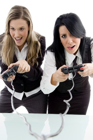 female partners playing game and holding remote against white backgroundの写真素材