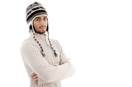 handsome man wearing woolen cap and posing with crossed arms on an isolated white backgroundの写真素材