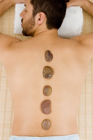 high angle view of man receiving hot stone massageの写真素材
