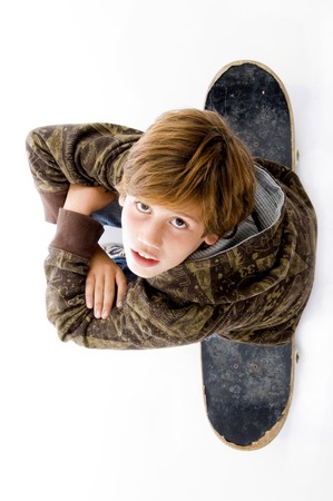 top view of boy sitting on skateboard on an isolated white backgroundの写真素材