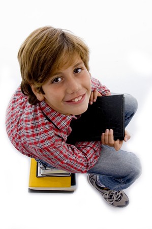 side view of boy sitting on pile of books on an isolated white background