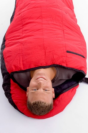 man taking rest in his sleeping bag on an isolated backgroundの写真素材