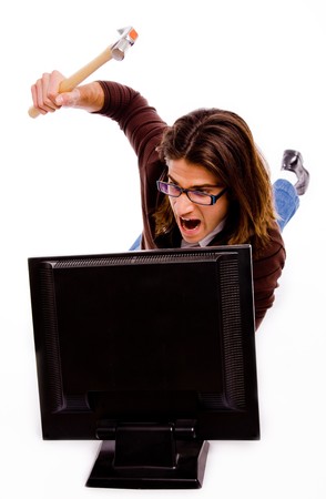 front view of angry man striking monitor with hammer on an isolated white backgroundの写真素材