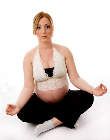 front view of pregnant female doing meditation with white backgroundの写真素材