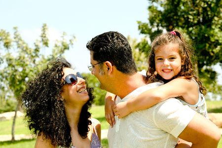 Couple exchanging words as mna holds kid on his backの写真素材