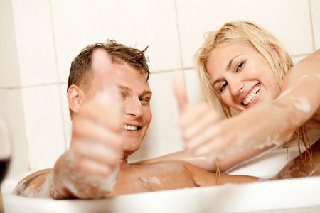 Smiling young couple showing thumbs upの写真素材