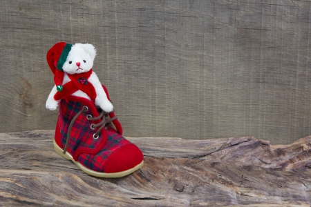White teddy-bear sitting in kids shoesの写真素材