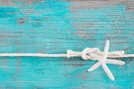 Turquoise wooden background for holiday concepts or beach with a starfish on a ropeの写真素材