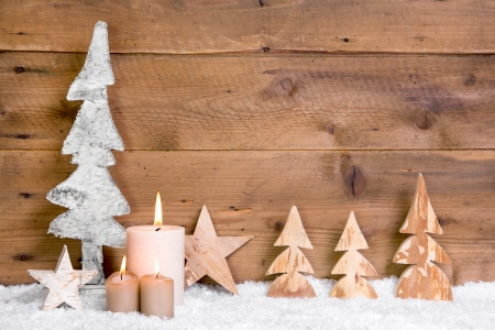 Natural wooden christmas decoration with snow and candle for a greeting cardの写真素材