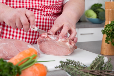 Overweight woman preparing ham - cooking at home の写真素材