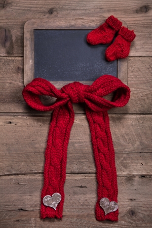 Chalk board with red knitted sock and bow on wooden for birthday or birthの写真素材