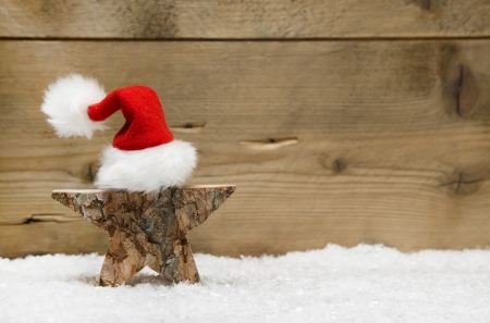 Wooden star with santa hat on wooden - handmade idea for a greeting cardの写真素材