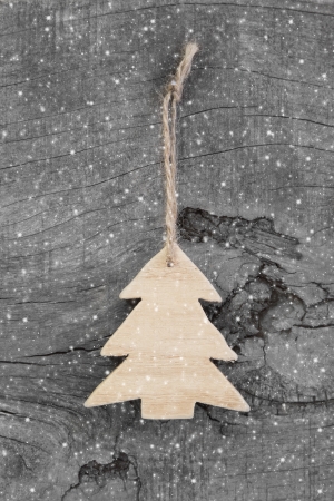 Wooden christmas carved tree - shabby style on a grey background for a greeting cardの写真素材