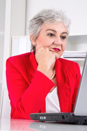 Senior business woman with laptop on workplaceの写真素材
