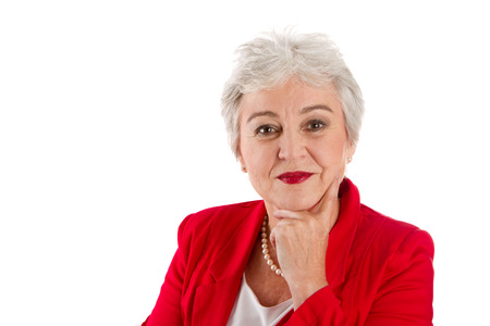 Portrait of a older woman isolated on white with a red blazerの写真素材