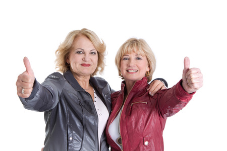 Gratulation  two older woman - girlfrieds - with thumbs upの写真素材