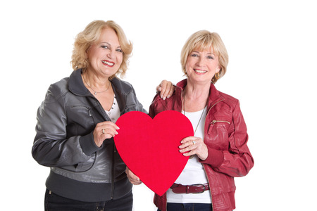 Elder women standing with a big hear-shape for love or valentineの写真素材