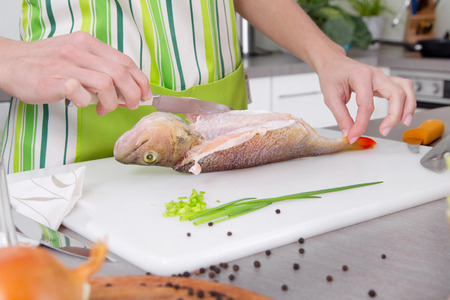 Preparing fresh fish at home at kitchen.