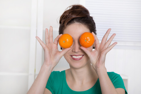 Smiling young woman with orange eyes.の写真素材