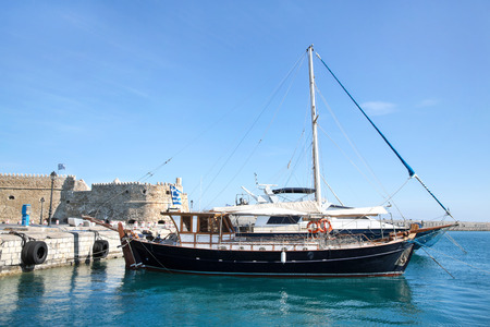 Greek island crete in the cyclades  sightseeing on the old port with fort and boats on blue sky の写真素材
