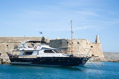 Greek island crete in the cyclades  sightseeing on the old port with fort and boats on blue sky の写真素材