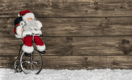 Wooden christmas background with santa on a bike. の写真素材