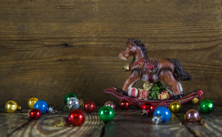 Colorful christmas background with a rocking horse and old balls.の写真素材