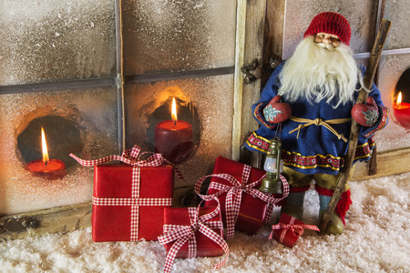 Rustic old santa claus with red presents: christmas country style window decoration.の写真素材