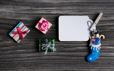 Christmas label or greeting card in red and blue colors on wooden background.
