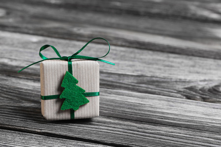 One green christmas present on wooden rustic grey background.の写真素材