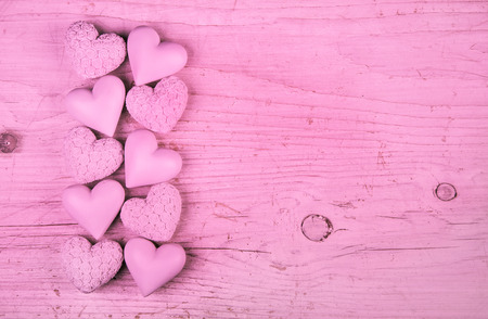 Pink or rose wooden background with hearts for valentine, birthday or wedding.の写真素材