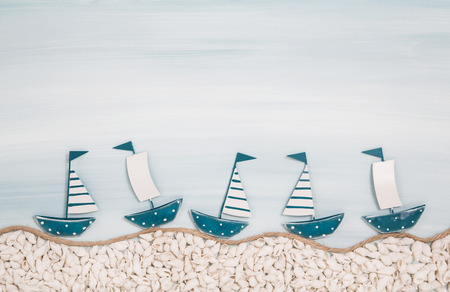 Five metal handmade sail boats on a blue ocean background for summer concepts.の写真素材