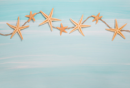 Tropical summer: blue or turquoise wooden background with shell and starfish.