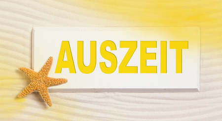 Traveling summer concept with the german word for time out in yellow and orange color.の写真素材