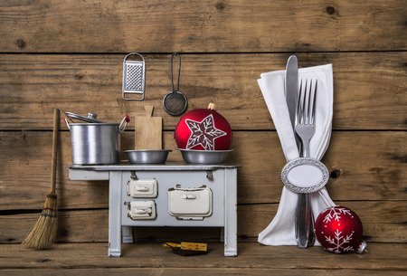 Old christmas decoration with cutlery, pots and other kitchen equipment on old wooden brown background.の写真素材