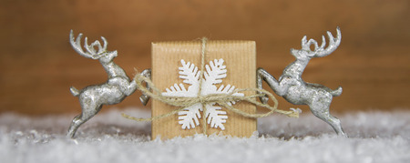 Christmas decoration with two silver moose holding a present.の写真素材