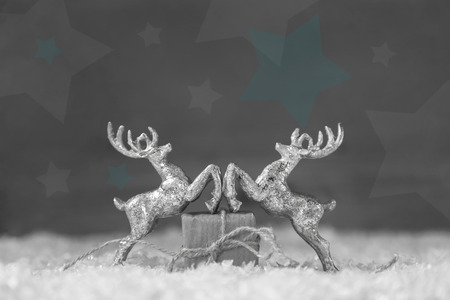 Two silver reindeer figurine on grey shabby style christmas background.の写真素材
