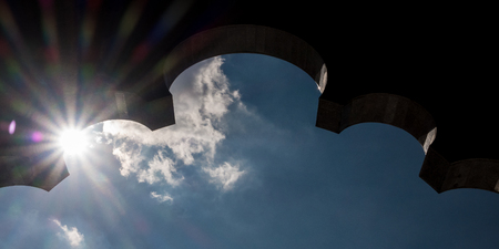 Sun shinning behind silhouette of an archの写真素材