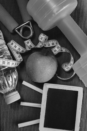 Flat lay- Dumbbell, Measuring Tape, Hand Grip, Mineral Water, Fresh Appleの写真素材