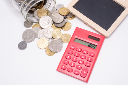 Jar of Malaysia Coins, Blank Blackboard for text, Red Calculator. White Background. Financial Concept. Shallow Depth of fieldの写真素材