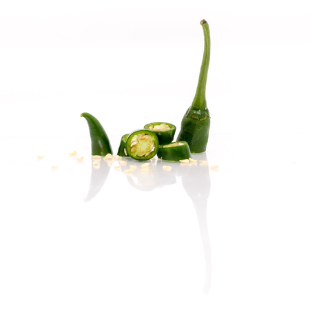 Isolated White Background - Green Chilis reflected. Shallow depth of fieldの写真素材