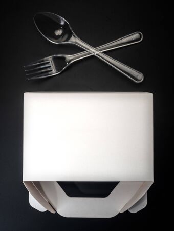 White Cardboard Fast Food Box, Packaging For Lunch and plastic fork and spoon. On black Background Isolated. Ready For Your business design\の写真素材