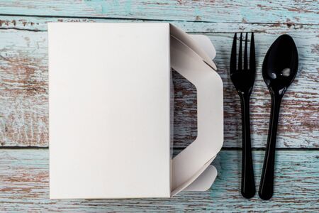White Cardboard Fast Food Box, Packaging For Lunch with Plastic fork and spoon. On wooden table. Ready For Your business design.の写真素材