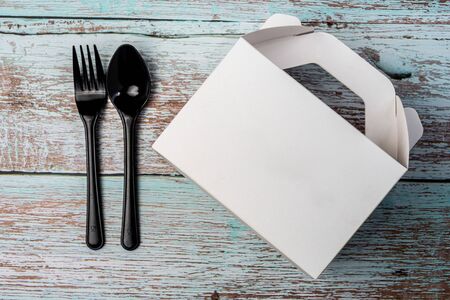 White Cardboard Fast Food Box, Packaging For Lunch with Plastic fork and spoon. On wooden table. Ready For Your business design.の写真素材