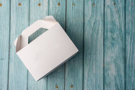 White Cardboard Fast Food Box, Packaging For Lunch on wooden table. Ready For Your business design.