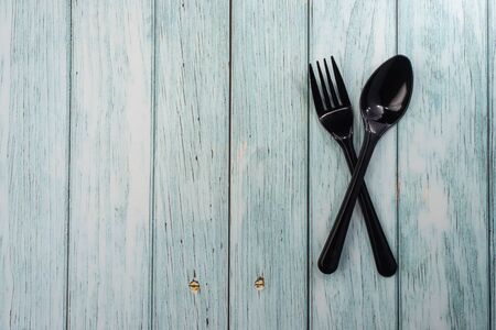 Plastic Spoon and Fork on wooden background. Negative spaceの写真素材