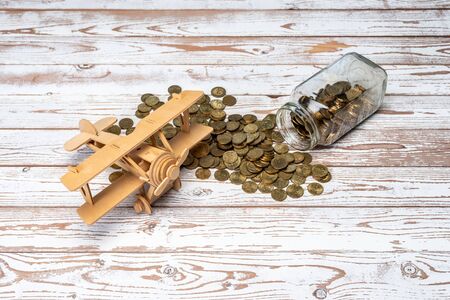 Toy Aeroplane and Malaysia Coins on wooden table. Savings for Travel, Holiday concept.