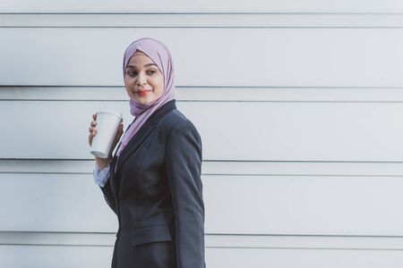 Muslim Female Worker with her smartphone during her coffee break.の写真素材